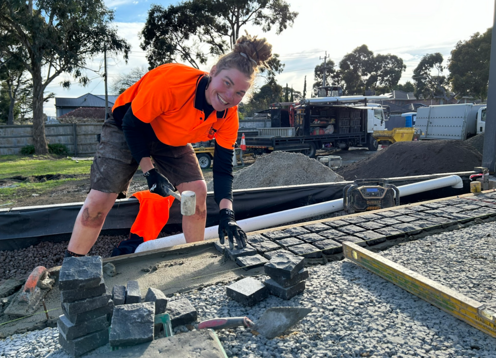 Dawn installing the cobblestones on a mortar bedding